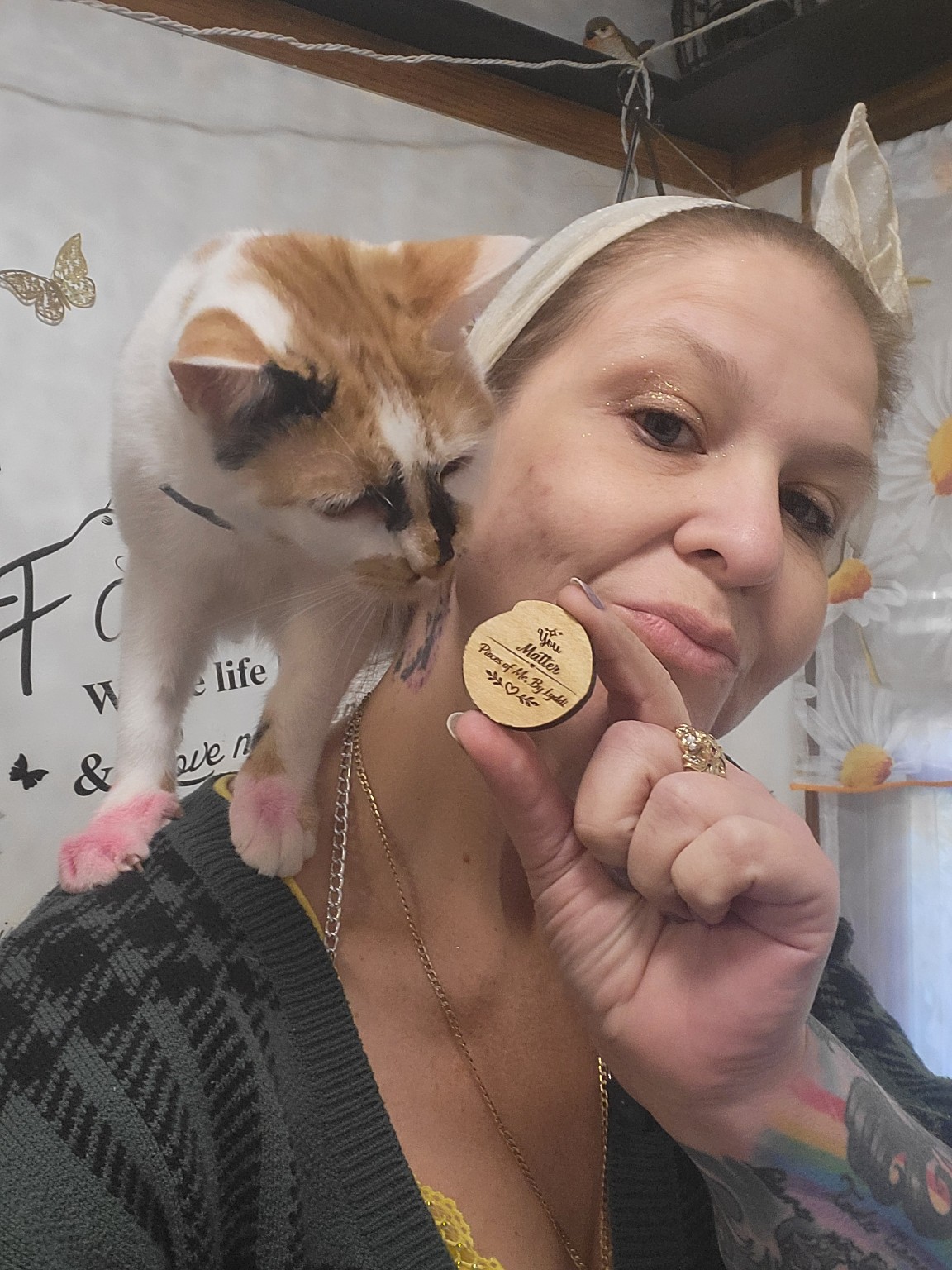Lyddi with her cat while holding a handmade token