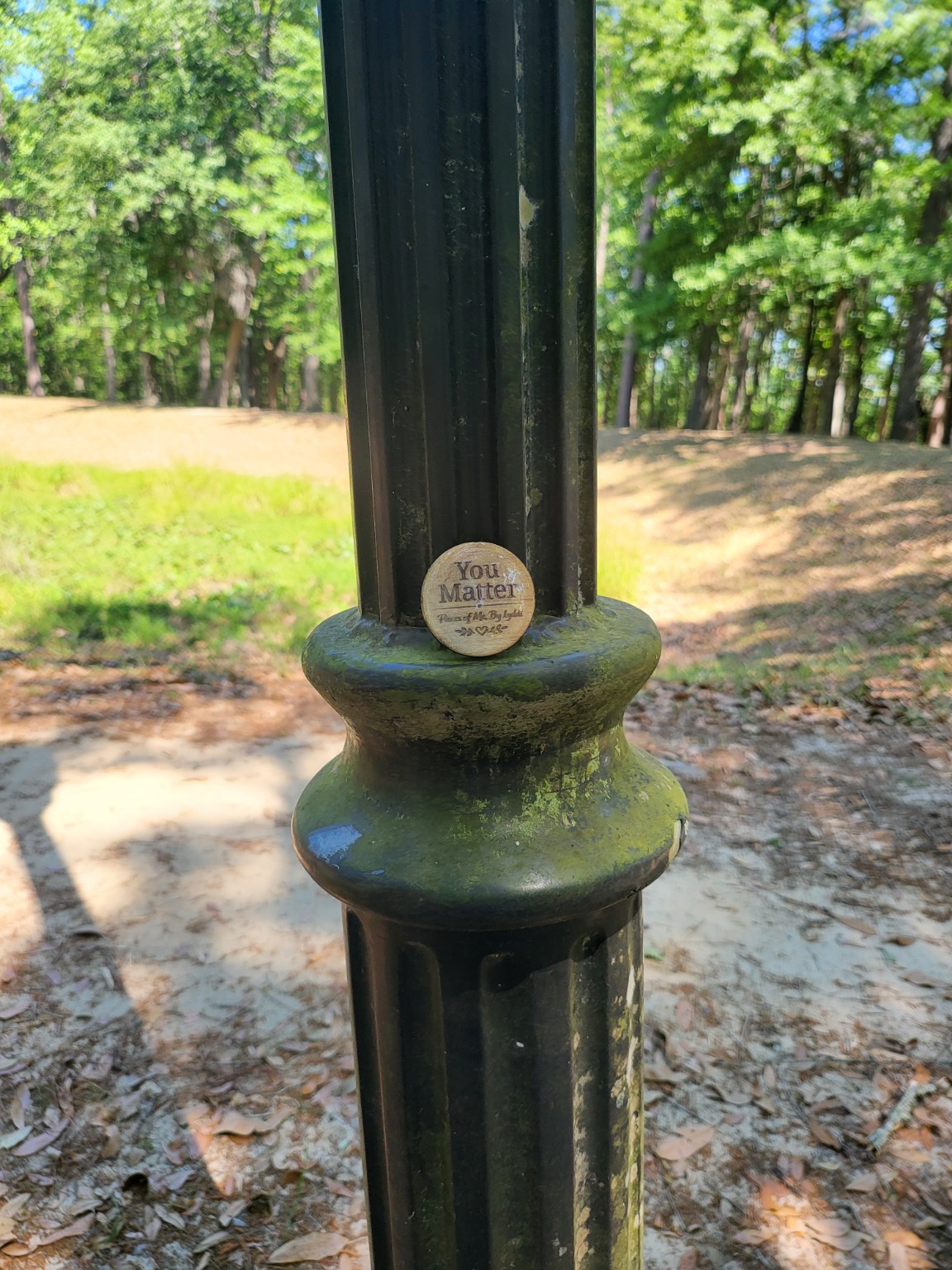 A heartwork token placed on an outdoor park post