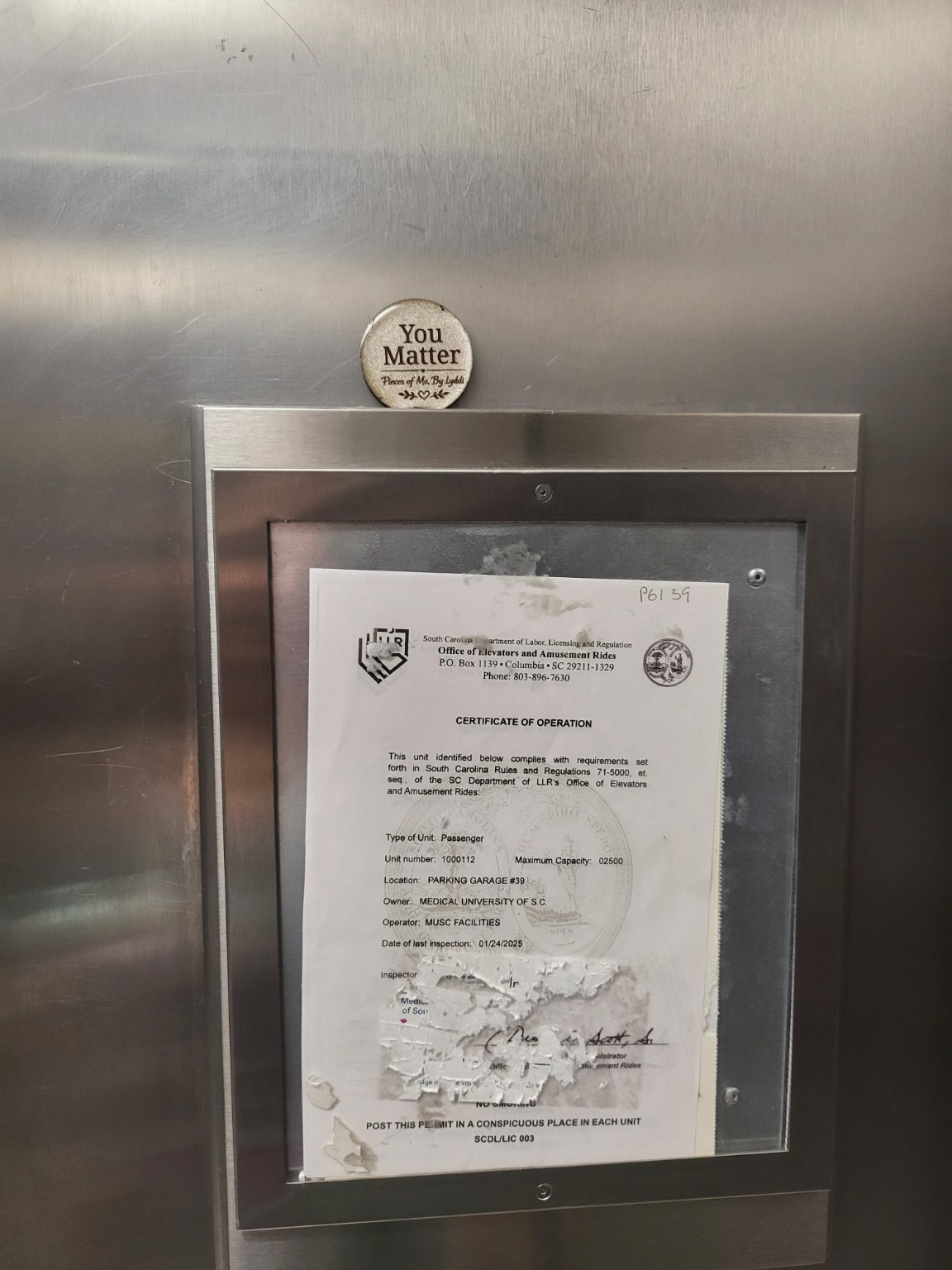 A heartwork token placed beside a framed public notice