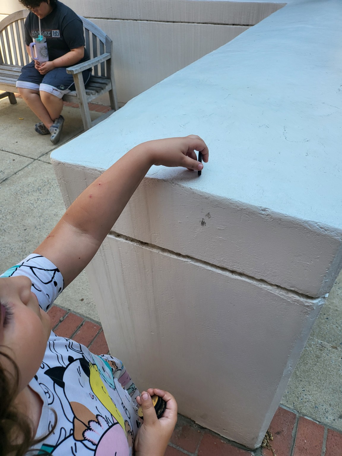 A young helper placing a heartwork token on a public ledge